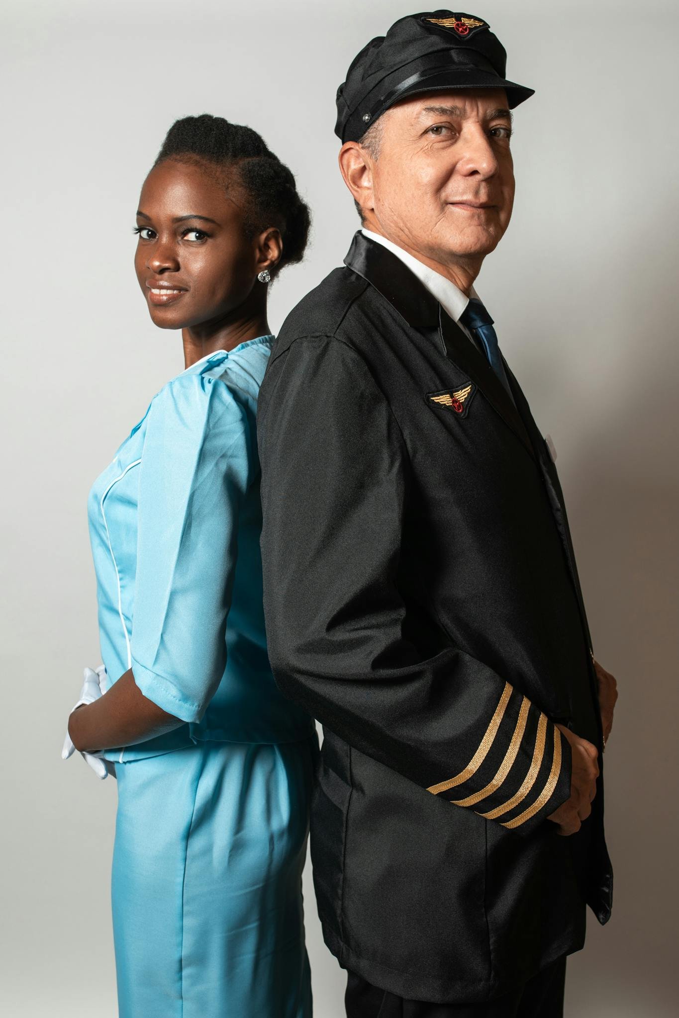 Professional portrait of a pilot and flight attendant in uniforms, standing back to back.